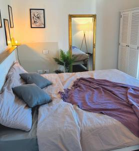 1 cama con almohadas en una habitación con espejo en Cottage indipendente con piscina privata, en Masi San Giacomo