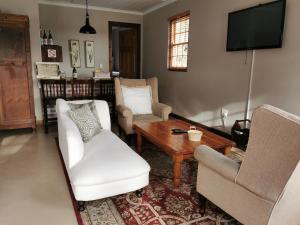 西薩默塞特的住宿－Somerset Grace Cottage，客厅配有两把椅子和一张桌子