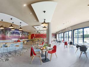 un restaurant avec des tables et des chaises et une cafétéria dans l'établissement Ibis El Jadida, à El Jadida