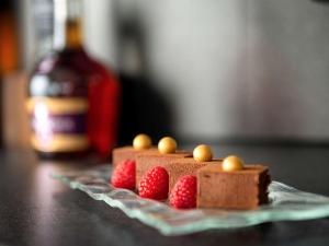 a piece of chocolate cake with raspberries on a table at Sofitel London Gatwick in Horley
