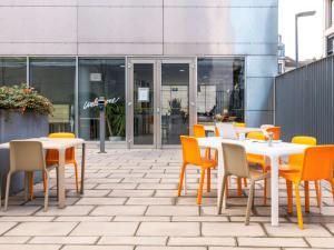 a group of tables and chairs in front of a building at Aparthotel Adagio Access Nancy Centre in Nancy