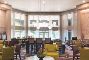 una hall con tavoli e sedie e un ristorante di La Quinta by Wyndham Atlanta Perimeter Medical ad Atlanta