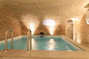 una piscina en una habitación con paredes de ladrillo y piscina en Une maison en ville, Hyper Centre ville, Spa en Amiens