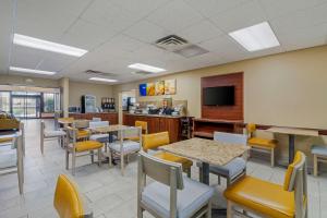 a dining room with tables and chairs and a tv at Comfort Inn Bismarck in Bismarck