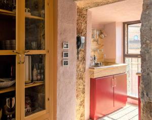 a kitchen with a red cabinet and a sink at Torre Salvucci Maggiore Medieval Tower Experience in San Gimignano