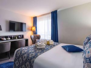 a hotel room with a bed with a stuffed animal on it at Mercure Bale Mulhouse Aeroport in Blotzheim