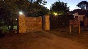 a wooden gate with a sign in front of a house at CABAÑAS MECHI in Mar del Plata