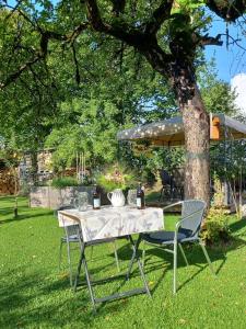 a table and chairs under a tree in a yard at Apartment Moosblick zwischen Bergen und See in Benediktbeuern