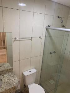 a bathroom with a toilet and a glass shower at Pousada Choppão in Feliz