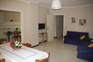 een woonkamer met een blauwe bank en een tafel bij Appartamento "Rina Centro Sicilia" in Pietraperzia