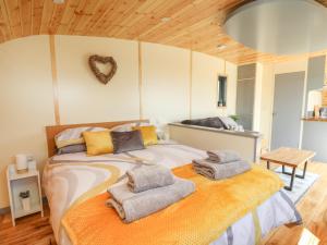 a bedroom with a bed with towels on it at Beacon View Pod in Knighton