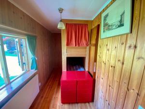 Habitación pequeña con banco rojo en una habitación en Beautiful 4-5 persons Cottage in Alvdalen, en Älvdalen