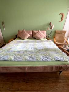 ノルダーナイにあるFerienwohnung Qi im Kaiserhof auf Norderneyの緑の壁のベッドルームのベッド1台