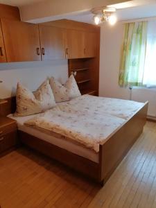 a bedroom with a large bed with wooden cabinets at Ferienwohnung Weppermühle 