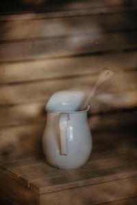 une tasse blanche avec une cuillère en bois dedans dans l'établissement Stiftsgården Tallnäs, à Skillingaryd