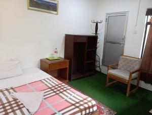a bedroom with a bed and a chair and a desk at Gurkha Lodge in Pokhara