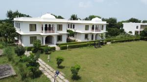 una gran casa blanca con un gran patio en ClarksInn Suites Ranthambhore, en Sawāi Mādhopur