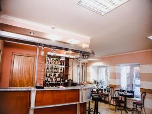 un bar en una habitación con mesa y sillas en Yuzhnaya Hotel, en Pyatigorsk