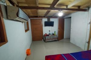 a room with a bed and a tv in it at EXPRESS O 91702 Mandeh Homestay Syariah in Painan