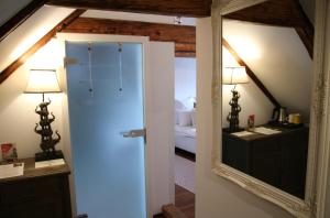 einen Spiegel in einem Zimmer mit einem Schlafzimmer in der Unterkunft L'Ostello Altstadthotel in Regensburg