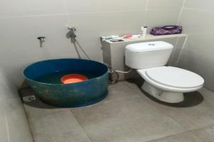 a bathroom with a bath tub next to a toilet at EXPRESS O 91702 Mandeh Homestay Syariah in Painan