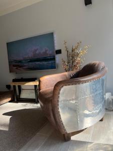 uma cadeira de couro castanho numa sala de estar com televisão em Limburg Lux 90 em Simpelveld