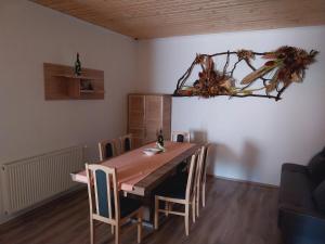 a dining room with a wooden table and chairs at Lovas Vendégház in Óbánya