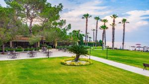 a park with tables and chairs and palm trees at Champion Holiday Village in Beldibi