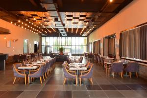 a restaurant with tables and chairs in a room at Hotel Yois in Udaipur