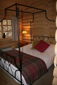 a bedroom with a bed in a log cabin at BCC Loch Ness Log Cabins in Bearnock