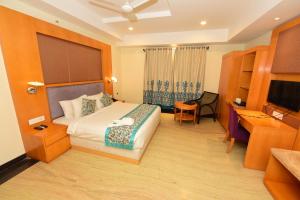 a hotel room with a bed and a desk at Hotel Yois in Udaipur