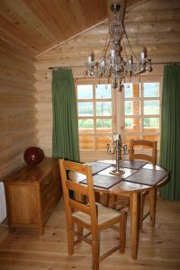 a dining room with a wooden table and a chandelier at BCC Loch Ness Log Cabins in Bearnock