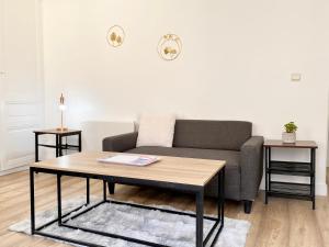 een woonkamer met een bank en een salontafel bij * Le Droma D’or * Appartement Confort * Centre-ville in Calais