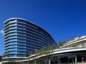 um edifício alto com um céu azul ao fundo em KOKO HOTEL Premier Kumamoto em Kumamoto