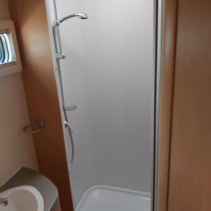 a shower in a bathroom with a toilet and a sink at Caravane Les Fontenelles in Saligny-sur-Roudon