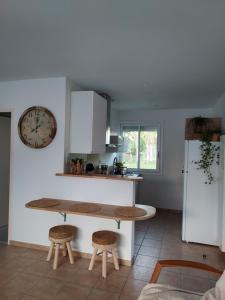 uma cozinha com uma mesa e algumas cadeiras e um frigorífico em Maison calme et chaleureuse em Châlette-sur-Loing