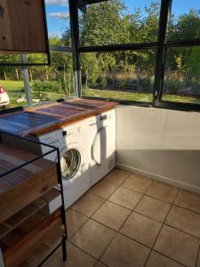 uma máquina de lavar e secar roupa num quarto com janelas em Maison calme et chaleureuse em Châlette-sur-Loing
