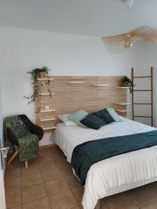 sypialnia z dużym łóżkiem i krzesłem w obiekcie Maison calme et chaleureuse w mieście Châlette-sur-Loing