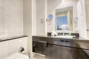 a bathroom with a sink and a toilet and a mirror at Intimate Studio in Damac Ghalia Jumeirah Village Circle by Deluxe Holiday Homes in Dubai