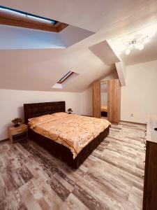 um quarto com uma cama grande e piso em madeira em Zizi's House Garii em Brasov