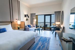 une chambre d'hôtel avec un lit et un salon dans l'établissement Amwaj Rotana, Jumeirah Beach - Dubai, à Dubaï