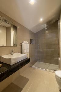 a bathroom with a tub and a sink and a shower at Luna Boutique Hotel in Mindelo