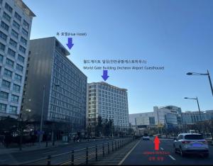 una calle de la ciudad con edificios y una mujer con un vestido rojo en Incheon Airport Guesthouse, en Incheon