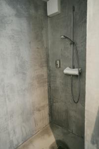 a shower with a shower head in a bathroom at The Layhead B&B in Lübeck
