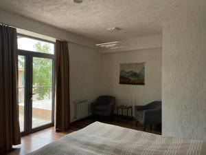 a bedroom with a bed and a sliding glass door at Apaga Resort in Ijevan