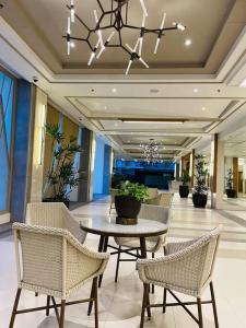 a lobby with a table and chairs and a chandelier at Stylish 1 bedroom condo with pool view and Fast WIFI in Manila