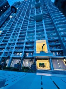 a tall blue building with a window in front of it at Stylish 1 bedroom condo with pool view and Fast WIFI in Manila