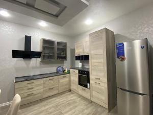 a kitchen with a stainless steel refrigerator and wooden cabinets at Villa Maria Dilijan in Dilijan