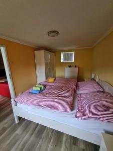2 camas en una habitación con almohadas rojas y blancas en Ferienwohnung an der Dresdner Heide - Langebrück, en Dresden
