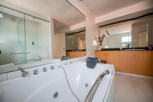 een grote badkamer met een bad en een grote spiegel bij spacious & stylish 4bdr kileleshwa in Nairobi